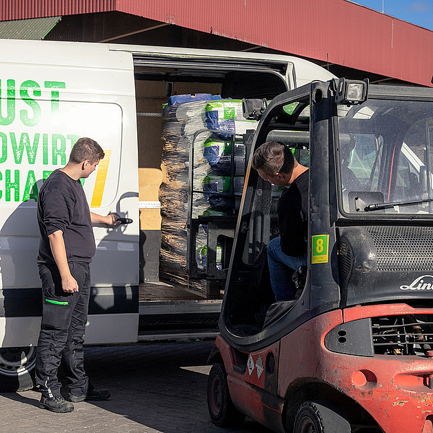 Auszubildende beladen einen Transporter mit einem Gabelstapler auf dem Heidesand-Gelände